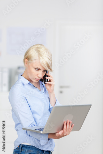 Photo: ernste geschäftsfrau mit telefon und laptop ernste geschäftsfrau mit telefon und laptop
