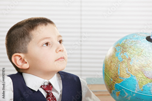 Photo: Schoolboy with globe looking sideways Schoolboy with globe looking sideways