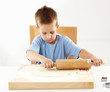 Small boy rolling dough for cookies