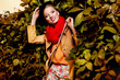 Photo: blonde woman wearing autumn clothes against wall of leaves blonde woman wearing autumn clothes against wall of leaves