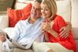 Photo: Senior Couple Relaxing On Sofa At Home Reading Newspaper Senior Couple Relaxing On Sofa At Home Reading Newspaper