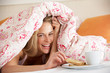 Photo: Pretty Woman Snuggled Under Duvet Eating Breakfast Pretty Woman Snuggled Under Duvet Eating Breakfast
