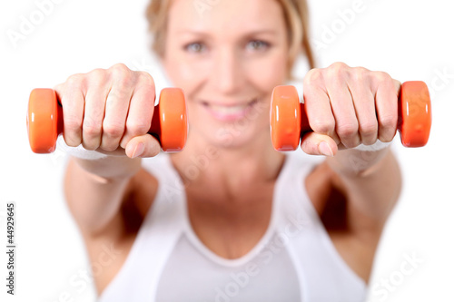 Photo: Woman using hand weights during fitness session Woman using hand weights during fitness session