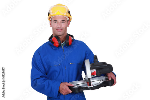 Photo: Tradesman holding a mitre saw Tradesman holding a mitre saw