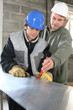Apprentice  and foreman on construction site