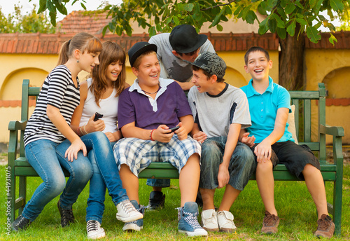 Photo: Teenage boys and girls having fun in the garden Teenage boys and girls having fun in the garden