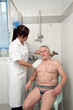 Senior wird von Pflegepersonal gebadet