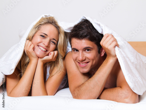 Photo: Paar hat Spass im Bett. Lachen, Freude und Erotik Paar hat Spass im Bett. Lachen, Freude und Erotik