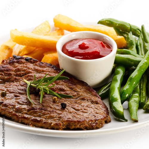 Photo: Grilled steaks, French fries and vegetables Grilled steaks, French fries and vegetables