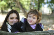 Mother and daughter stood by log