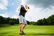 Young golf player on course doing golf swing