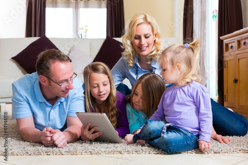 Photo: Familie spielt mit dem Tablet computer daheim Familie spielt mit dem Tablet computer daheim