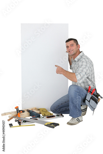Photo: Handyman pointing to a blank sign Handyman pointing to a blank sign