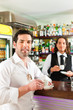 Barista with client in his cafe or coffeeshop