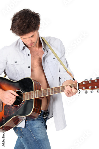 Photo: Young man playing a guitar Young man playing a guitar