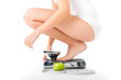 Young woman sitting on her haunches on a scale