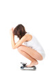 Young woman sitting on her haunches on a scale