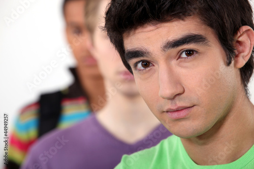 Photo: Young man standing beside his friends Young man standing beside his friends
