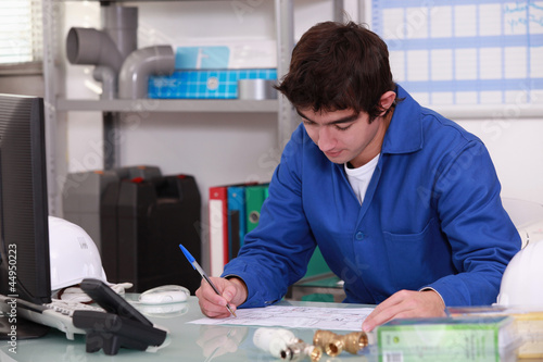 Photo: Young apprentice checking stock Young apprentice checking stock