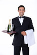 Smart waiter holding tray of champagne glasses