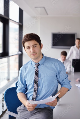 Photo: business man on a meeting in offce with colleagues in backgroun business man on a meeting in offce with colleagues in backgroun