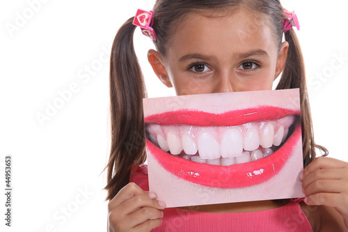 Photo: Little girl holding photo of mouth Little girl holding photo of mouth