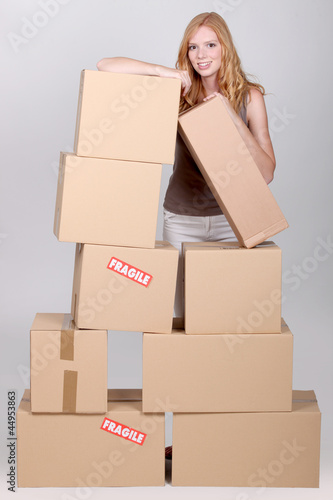 Photo: Young woman surrounded by cardboard boxes Young woman surrounded by cardboard boxes