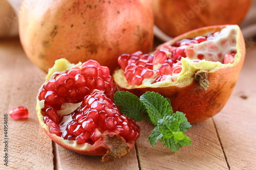 Photo: pomegranate ripe fruit on a wooden table pomegranate ripe fruit on a wooden table