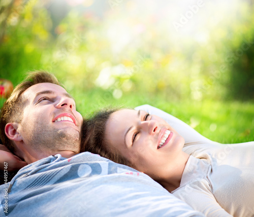 Photo: Young Couple Lying on Grass Outdoor Young Couple Lying on Grass Outdoor