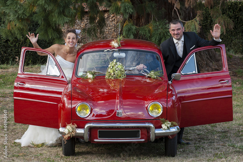 Photo: jeunes mariés et leur voiture rouge jeunes mariés et leur voiture rouge