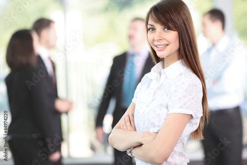 Photo: Face of beautiful woman on the background of business people Face of beautiful woman on the background of business people