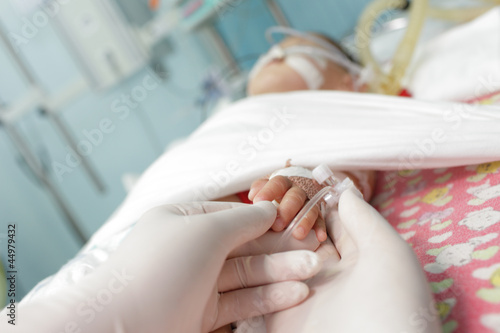 Photo: hands in gloves touches and holds hand a little sick child. conc hands in gloves touches and holds hand a little sick child. conc