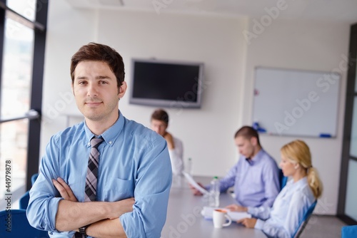 Photo: business man on a meeting in offce with colleagues in backgroun business man on a meeting in offce with colleagues in backgroun