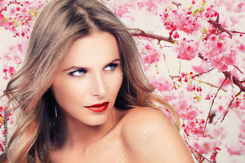 Photo: Beautiful, fresh woman on floral Background. Long hair girl. Beautiful, fresh woman on floral Background. Long hair girl.
