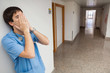 Nurse with hands in face in hospital corridor