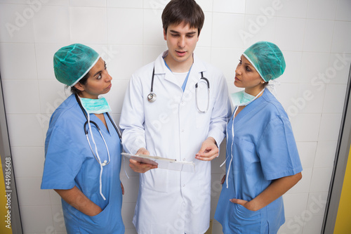 Photo: Doctor talking to two nurses Doctor talking to two nurses