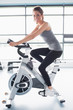 Photo: Smiling woman training on exercise bike Smiling woman training on exercise bike