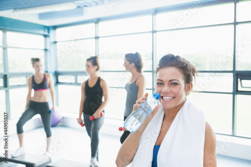 Photo: Woman with bottle of water in aerobics class Woman with bottle of water in aerobics class