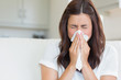 Photo: Brunette sneezing in a tissue Brunette sneezing in a tissue