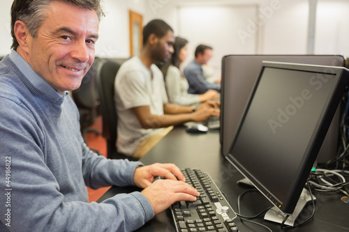 Photo: Smiling man sitting in front of the computer Smiling man sitting in front of the computer