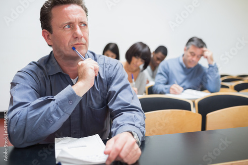 Photo: Man thinking while writing Man thinking while writing