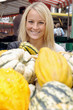 Junge Frau auf Markt mit Kürbissen