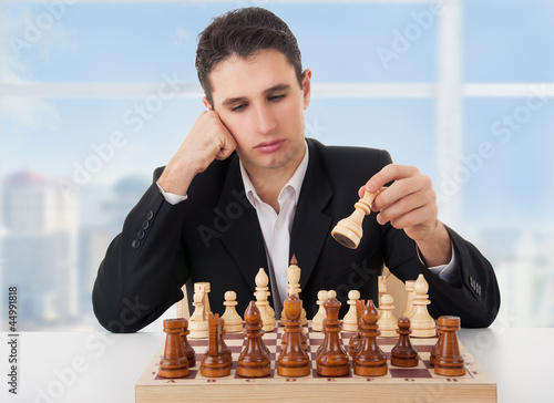 Photo: business man playing chess, making the move business man playing chess, making the move