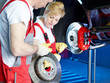 Photo: Two car mechanics are checking the brake of a car Two car mechanics are checking the brake of a car