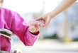 Senior Lady in Wheelchair Holding Hands