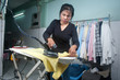 Asian woman in black clothes working with iron .