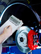 Car mechanic makes a calculation of repair costs for a brake