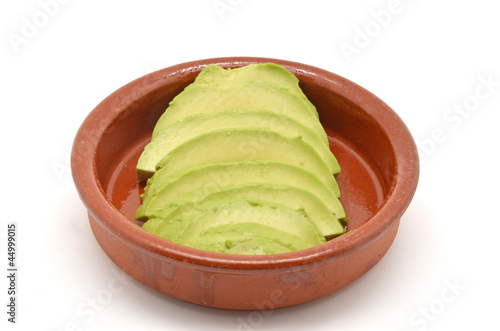 Photo: avocado cut into clay bowl avocado cut into clay bowl
