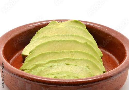 Photo: avocado cut into clay bowl avocado cut into clay bowl