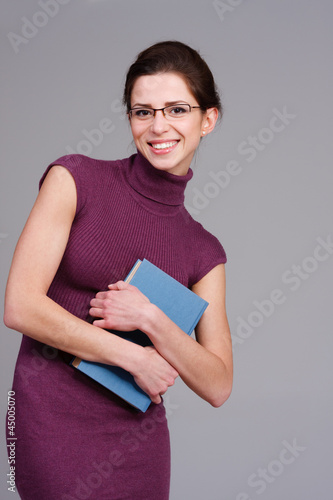 Photo: strahlende junge frau mit einem buch strahlende junge frau mit einem buch